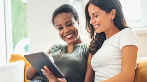 Two women, watching media on a tablet