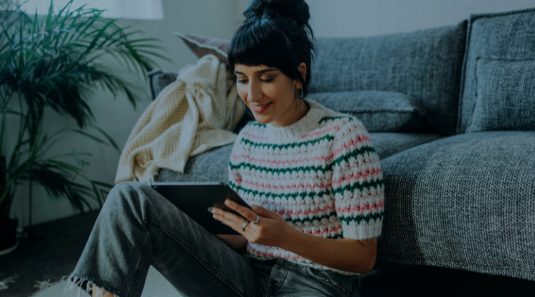 A Young Female Sitting On The Floor And Watching A Podcast On Her Tablet