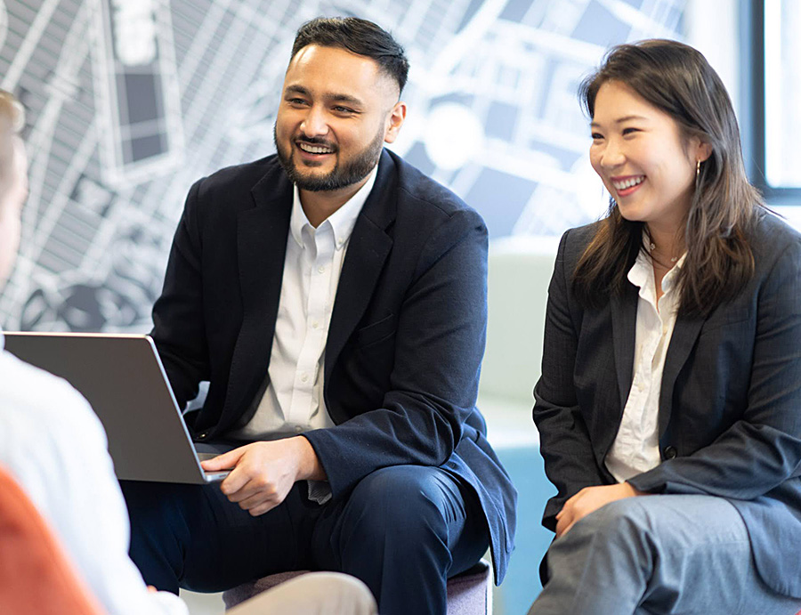 Young woman and man sitting together and smiling in the office