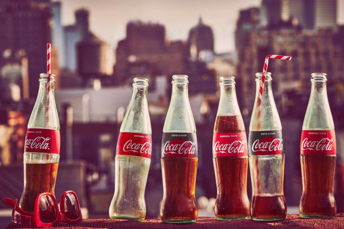 Coca-Cola glass bottles set against a skyline