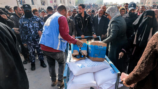 Des employés de l'Unrwa distribuent des sacs de farine aux civils à Rafah, dans le sud de la bande de Gaza, en décembre 2023.
