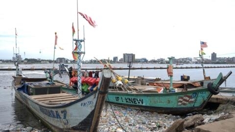 Deux pirogues à quai sur un quai de débarquement de pêche artisanale à Abidjan.