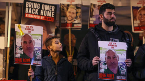 Manifestantes levantan retratos de Elad Katzir durante una protesta a favor de los familiares y simpatizantes de los rehenes israelíes retenidos en Gaza desde los ataques del 7 de octubre por militantes palestinos de Hamás, durante una concentración para pedir su liberación en Tel Aviv el 3 de febrero de 2024.