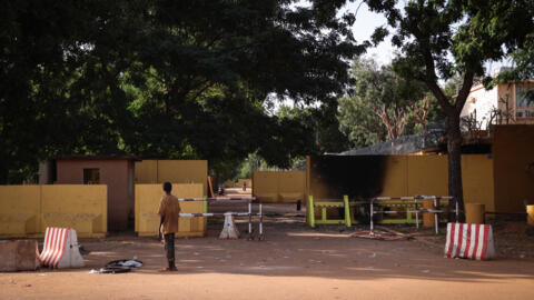 A man pauses in front of the damaged entrance to the French embassy in Ouagadougou, Burkina Faso, on October 3, 2022.