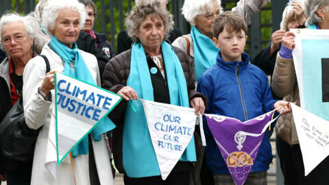 Protesters hold pennants during a rally before the European Court of Human Rights (ECHR) decides in three separate cases if states are doing enough in the face of global warming.