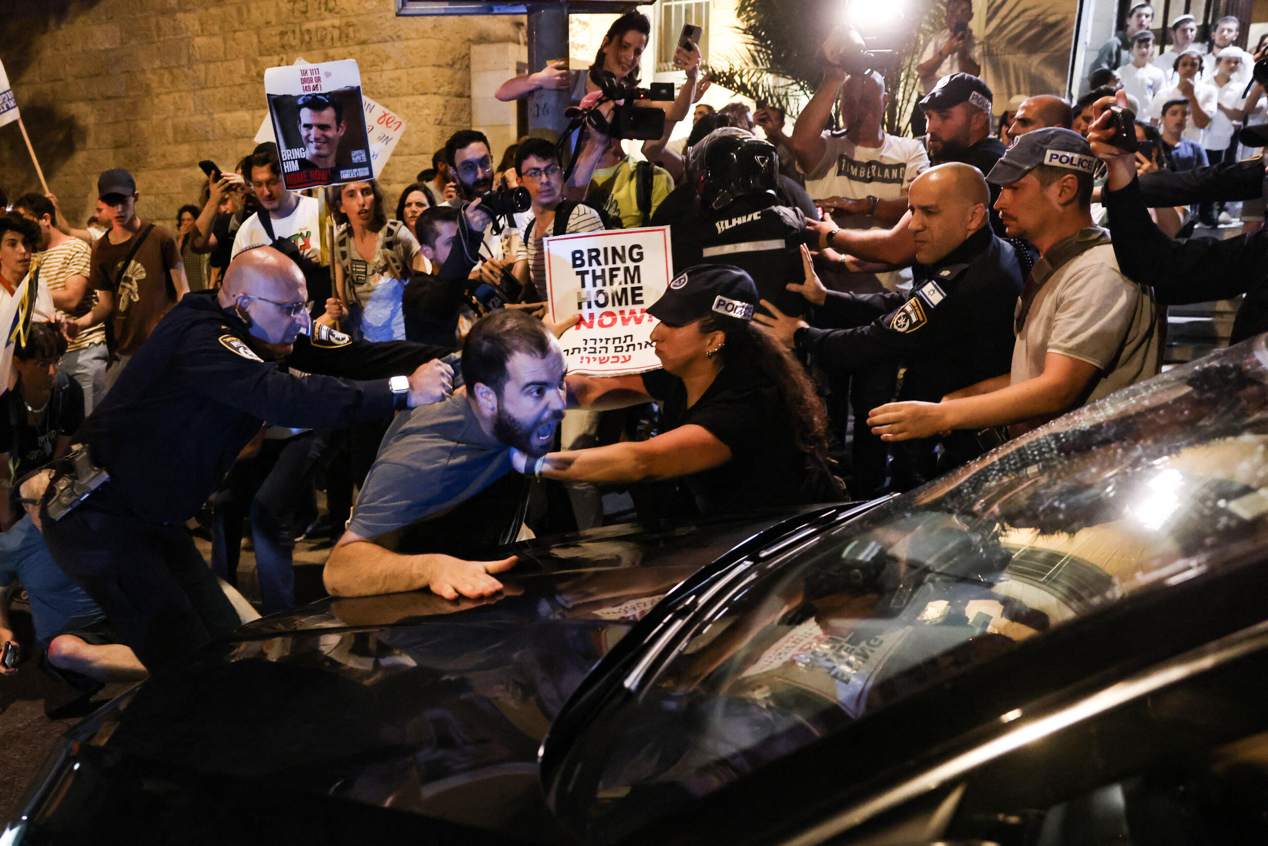 Un manifestant frappe le capot d'une voiture conduisant le ministre de la Sécurité nationale d'extrême droite, Itamar Ben Gvir, lors d'une manifestation à Jérusalem, le 24 avril 2024.