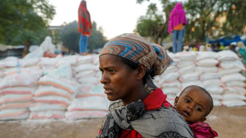 A woman carries an infant in the town of Shire,Ethiopia, March 15, 2021.