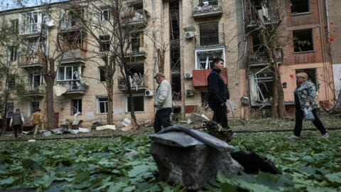 Local residents walk near an apartment building damaged by a Russian air strike, amid Russia's attack on Ukraine, in Kharkiv, Ukraine on May 5, 2024. 