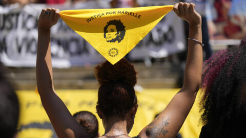 A woman holds a scarf with the image of slain councilwoman Marielle Franco during a protest marking the sixth anniversary of her murder in Rio de Janeiro, Brazil, Thursday, March 14, 2024.