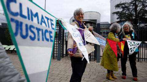 Simpatizantes y miembros de la asociación Senior Women for Climate Protection sostienen pancartas cuando llegan al fallo en el caso climático Verein KlimaSeniorinnen Schweiz y otros contra Suiza, ante el Tribunal Europeo de Derechos Humanos.