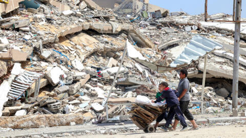 De jeunes Palestiniens collectent des cartons et des palettes en bois à Beit Lahya, dans le nord de la bande de Gaza, le 4 mai 2024.