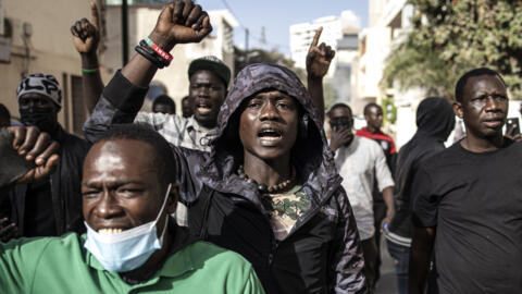 Protesters gesture after police fired teargas during scuffles outside the National Assembly in Dakar on February 5, 2024.