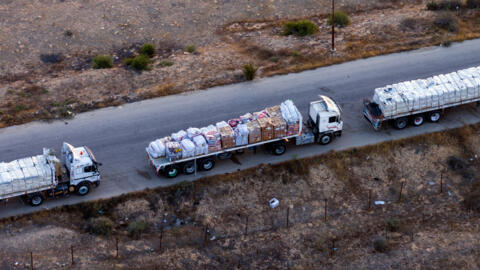 Des camions transportant de l'aide humanitaire attendent sur une route égyptienne le long de la frontière avec Israël, près du passage frontalier de Rafah avec la bande de Gaza, le 2 mai 2024.