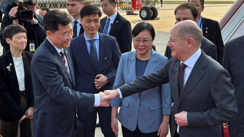 German Chancellor Olaf Scholz shakes hands with Chinese Ambassador to Germany Wu Ken next to Chongqing Vice Mayor Zhang Guozhi, upon arriving at the airport in Chongqing, China on April 14, 2024.