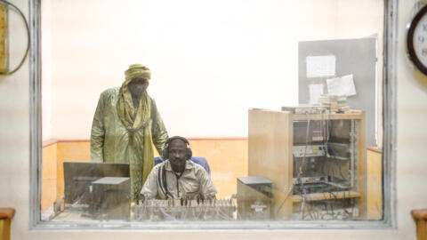 ORTM journalist Yahia Tandina (L) talks with his technician during a radio broadcast at the Timbuktu office in Timbuktu, Mali on December 7, 2021. 