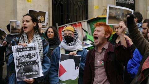 متظاهرون يحملون لافتات كتب عليها "تفكيك الحدود الاستعمارية" بينما يحتل الطلاب مبنى في جامعة العلوم السياسية في باريس، احتجاجا على الحرب في غزة. في باريس، فرنسا، في 26 إبريل 2024.