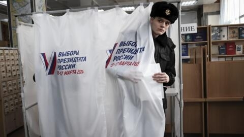 A young man leaves a voting booth at a polling station in the Pacific port city of Vladivostok, Russia, on March 15, 2024.