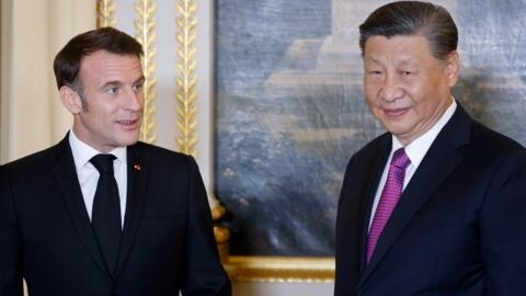 French President Emmanuel Macron (L) speaks with Chinese President Xi Jinping (R) ahead of an official state dinner as part of Xi's two-day state visit to France, at the Élysée Palace in Paris.