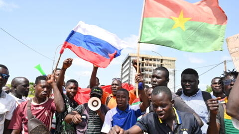 Des drapeaux de la Russie et du Burkina Faso sont brandis par un petit groupe de manifestants qui protestent contre la Cédéao, le 4 octobre 2022.
