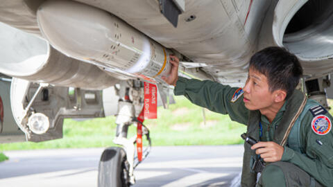 A Taiwanese air force pilot inspecting ordnance on an Indigenous Defense Fighter at an undisclosed military base in Taiwan.