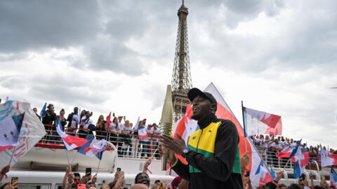 الجمايكي يوسين بولت، أسطورة سباقات السرعة في ألعاب القوى، يحمل شعلة أولمبياد باريس 2024 قرب برج إيفل قبل عام من انطلاق الحدث الرياضي العالمي البارز.