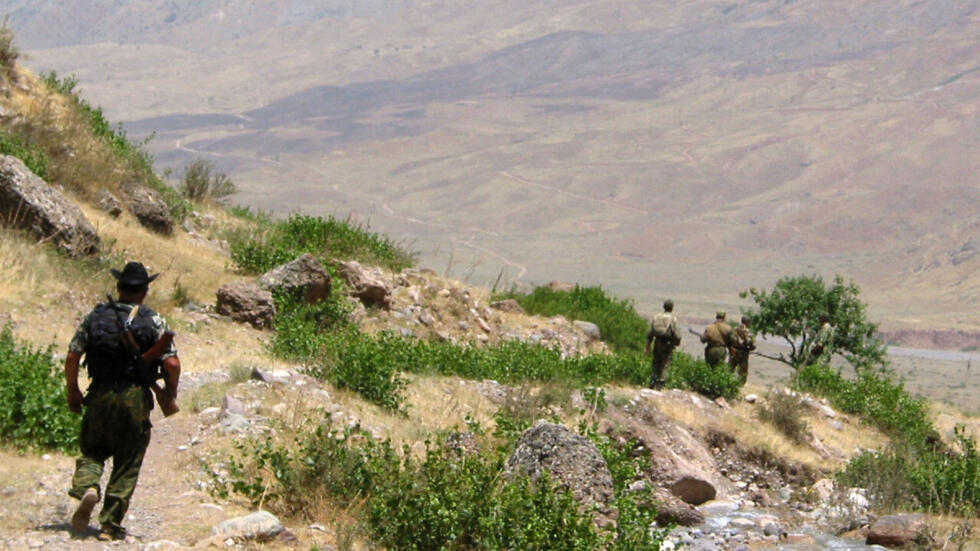 Des gardes-frontières tadjiks marchent sur un sentier près de la frontière afghane.