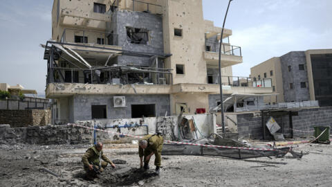 Israeli security forces examine the site hit by a rocket fired from Lebanon, in Kiryat Shmona, northern Israel, on March 27, 2024.