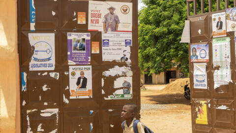 A child walks past campaign posters in Lome, Togo on April 24, 2024.