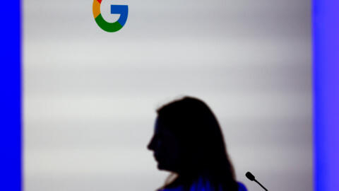 A woman stands in front of a Google logo during the inauguration of a new hub dedicated to artificial intelligence (AI) sector, at Google France headquarters in Paris,February 15,2024.