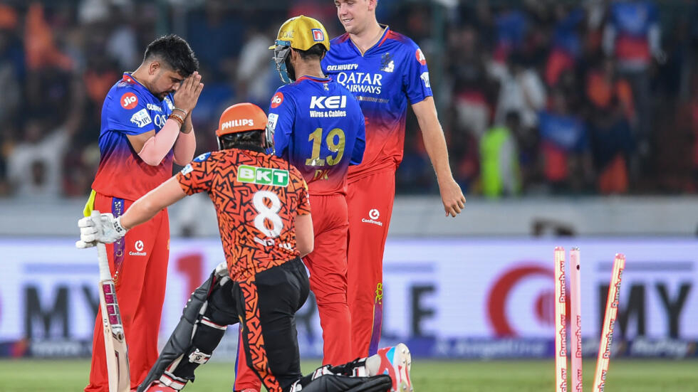 Royal Challengers Bengaluru's Karn Sharma (L) celebrates with teammates after taking the wicket of Sunrisers Hyderabad's Nitish Kumar Reddy during their Indian Premier League Twenty20 cricket match in Hyderabad on April 25, 2024