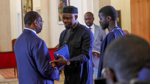 L'ancien chef de l'opposition sénégalaise, Ousmane Sonko, serre la main du président sortant, Macky Sall, à côté du président élu du Sénégal, Bassirou Diomaye Faye, au palais présidentiel de Dakar, le