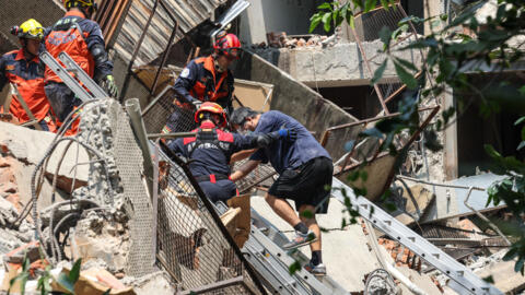 Esta foto tomada por la Agencia Central de Noticias de Taiwán (CNA) el 3 de abril de 2024 muestra a los trabajadores de emergencia ayudando a un sobreviviente después de que fue rescatado de un edificio dañado en la ciudad de Nuevo Taipéi, después de que un terremoto azotara el este de Taiwán.