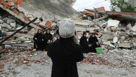 Archivo. Los residentes de la aldea de Aita al-Shaab, en el sur del Líbano, posan para una fotografía frente a una casa que fue destruida por un bombardeo israelí anterior, mientras visitan su aldea desierta con motivo del funeral de un combatiente de Hezbolá, el 9 de abril de 2024.