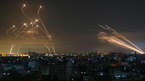 The Israeli Iron Dome missile defence system (L) intercepts rockets (R) fired by the Hamas movement towards southern Israel from Beit Lahia in the northern Gaza Strip as seen in the sky above the Gaza