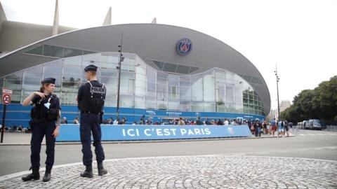 (FILES) Police officers stand as supporters gather outside French football club Paris Saint-Germain's (PSG) Parc des Princes stadium in Paris on August 10, 2021.