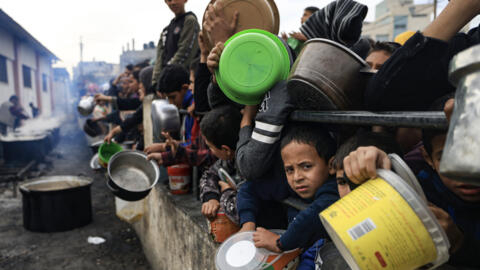 Palestinians children wait to collect food at a donation point in a refugee camp in Rafahs, southern Gaza -- t