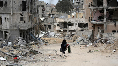 Une femme palestinienne marche dans un quartier dévasté par les bombardements israéliens à Khan Younès, dans le sud de la bande de Gaza, le 25 avril 2024.