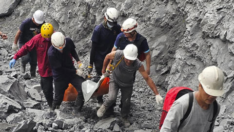 Des pompiers et des travailleurs de la carrière évacuent un corps de la carrière Ho Ren, au lendemain du puissant tremblement de terre qui a frappé le comté de Hualien, dans l'est de Taïwan, le 4 avri