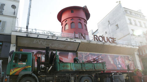 Des ouvriers sécurisent la zone devant le Moulin Rouge à Paris après que ses ailes et des lettres de la façade sont tombées dans la nuit sans faire de blessés, le 25 avril 2024.