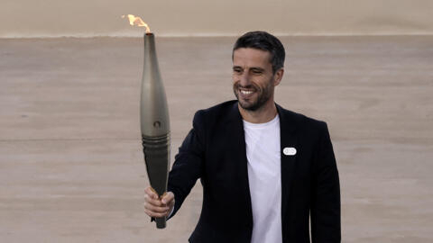 Tony Estanguet, president of the Paris 2024 Olympics organising committee, holds the Olympic flame during the Handover Ceremony on April 26, 2024. 