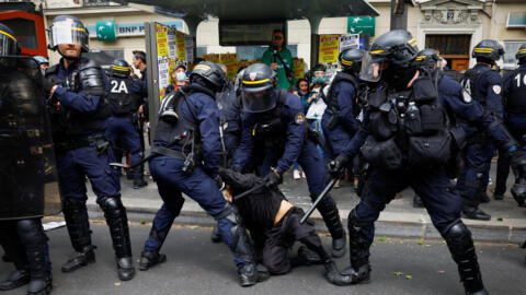 Riot police subdue a demonstrator during the traditional May Day labour union march in Paris on May 1, 2024.