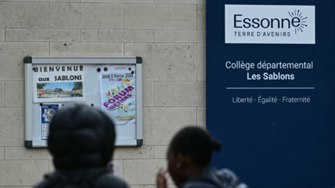 Middle schoolers stand before the entrance of the school Les Sablons in Viry-Chatillon on April 5, 2024, a day after a teenage boy was assaulted and rushed to the hospital.