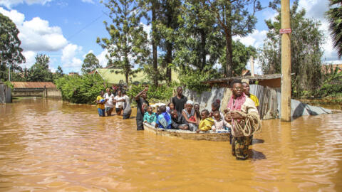 A family uses a boat after fleeing floodwaters that wreaked havoc in the Githurai area of Nairobi, Kenya on April 24, 2024. 
