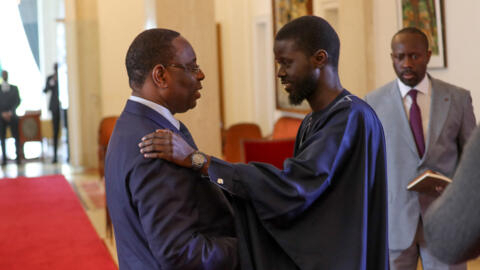 This handout picture taken an distributed by the Senegalese Presidency on March 28, 2024 shows outgoing Senegalese President Macky Sall (L) greeting Senegal's president-elect Bassirou Diomaye Faye.