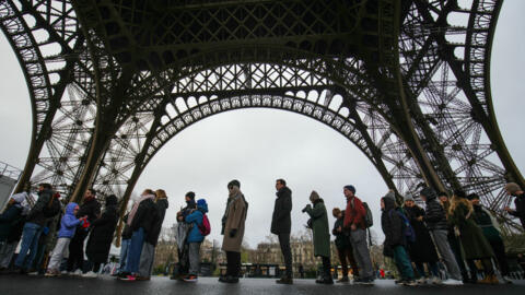 Visitors line up to enter the Eiffel Tower, on the day of its reopening after a six-day strike, in Paris on February 25, 2024.
