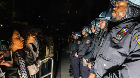 Pro-Palestinian students and activists face police officers as they protest the Israel-Hamas war on the campus of New York University (NYU) in New York on April 22, 2024.