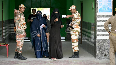 Deux femmes voilées arrivent dans un bureau de vote à Kairana, i dans l'État indien de l'Uttar Pradesh, vendredi 19 avril 2024.