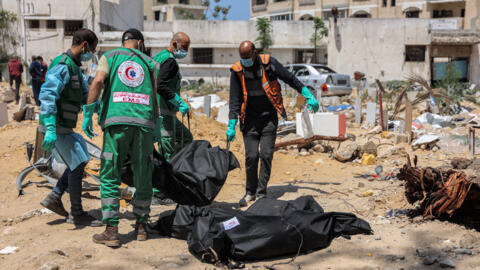 عمال من الصحة في غزة يحملون جثة عثر عليها في مقبرة بمستشفى ناصر في خان يونس، 17 أبريل 2024.