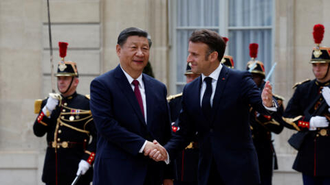 French President Emmanuel Macron welcomes China's President Xi Jinping as he arrives for a meeting  at the Elysee Palace in Paris as part of the Chinese president's two-day state visit in France, May