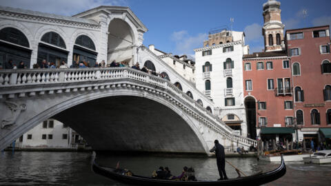Une gondole navigue sous le pont du Rialto à Venise, le 24 avril 2024.
